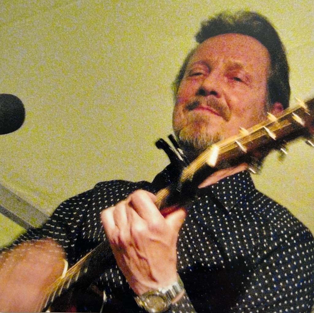 Pave Maijanen soittaa vanhassa valokuvassa kitaraa. Kuva: Maijasen kotiarkisto
